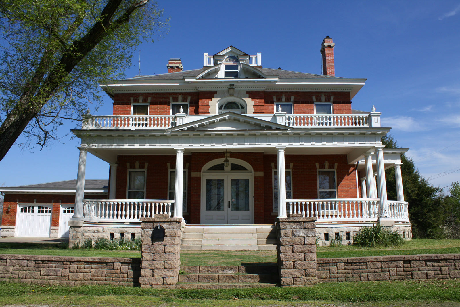 Restored historic brick home with a wraparound porch